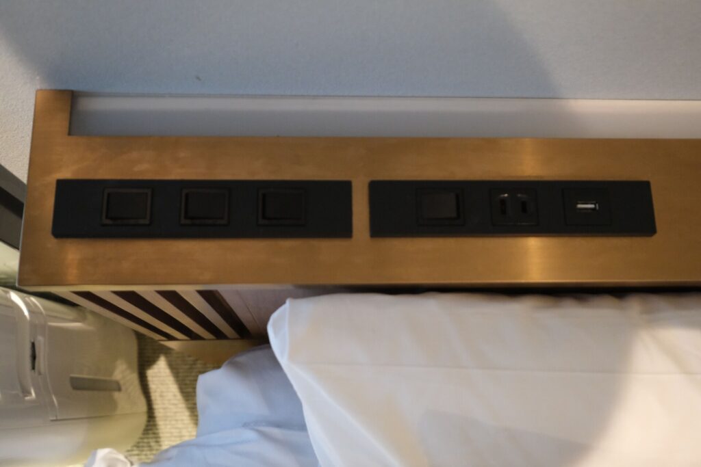Two switches are pocketed in the headboard with a single power outlet and USB type A port. 
