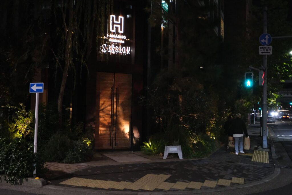 The Session Restaurant entry, a view from the street at night.