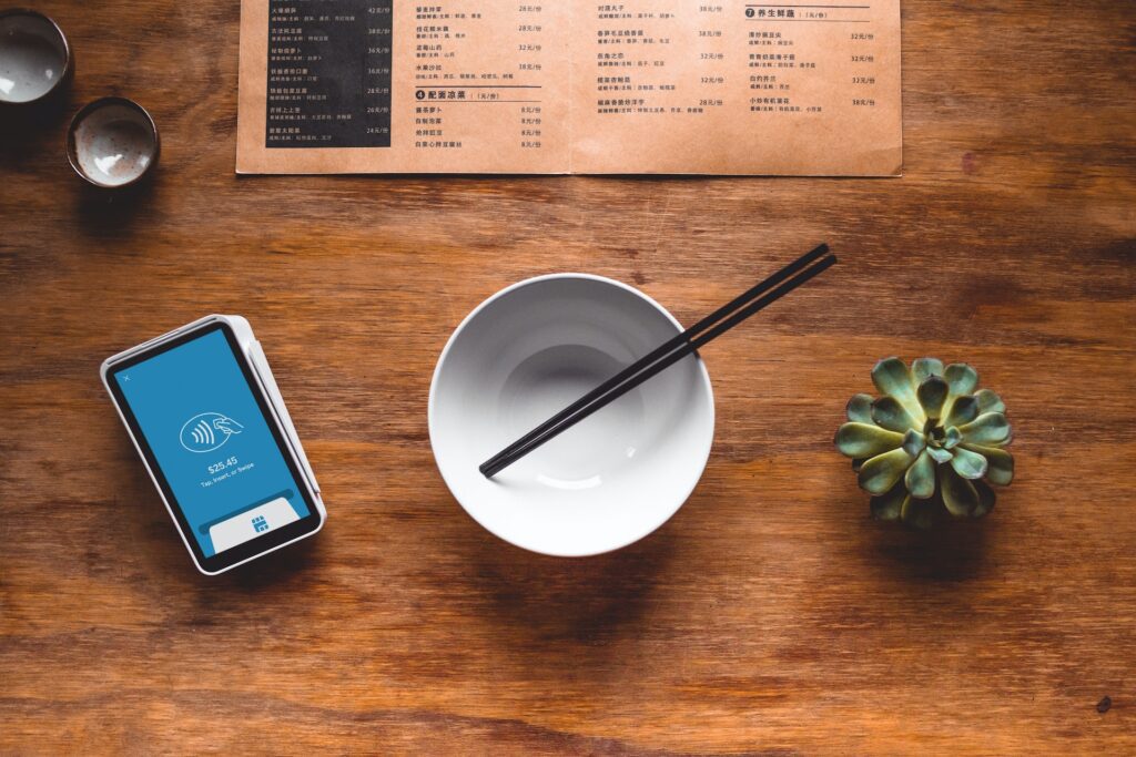 empty bowl with chopsticks next to payment terminal