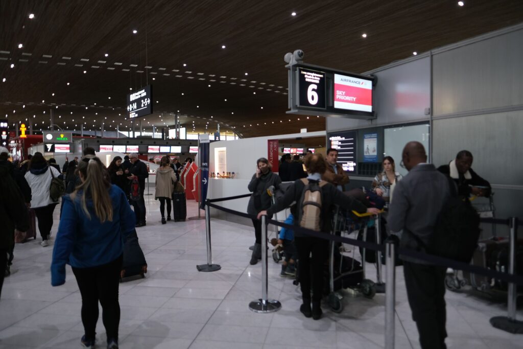 A busy Air France Business Class holiday Check-In at Terminal 2E - counters packed with passengers.