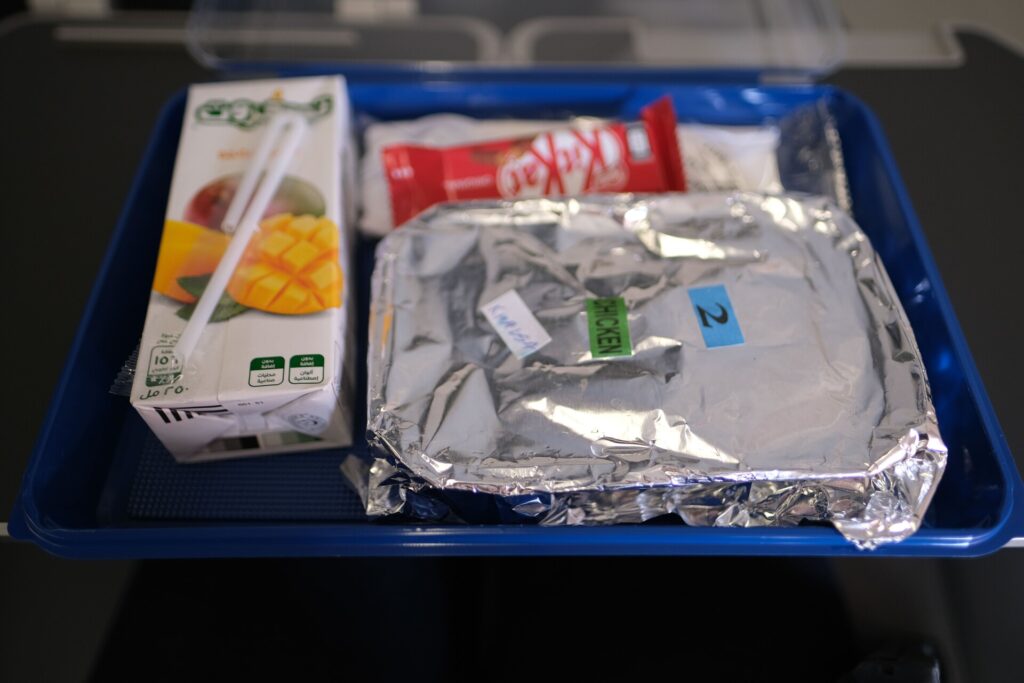 Contents include the Entree, a small box of Mango juice, a Kit Kat bar for snack and plastic utensils.