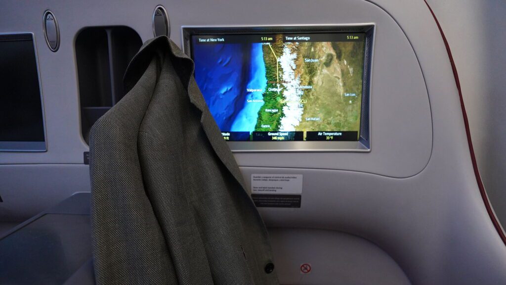 LATAM business class coat hangers are next to the IFE screen