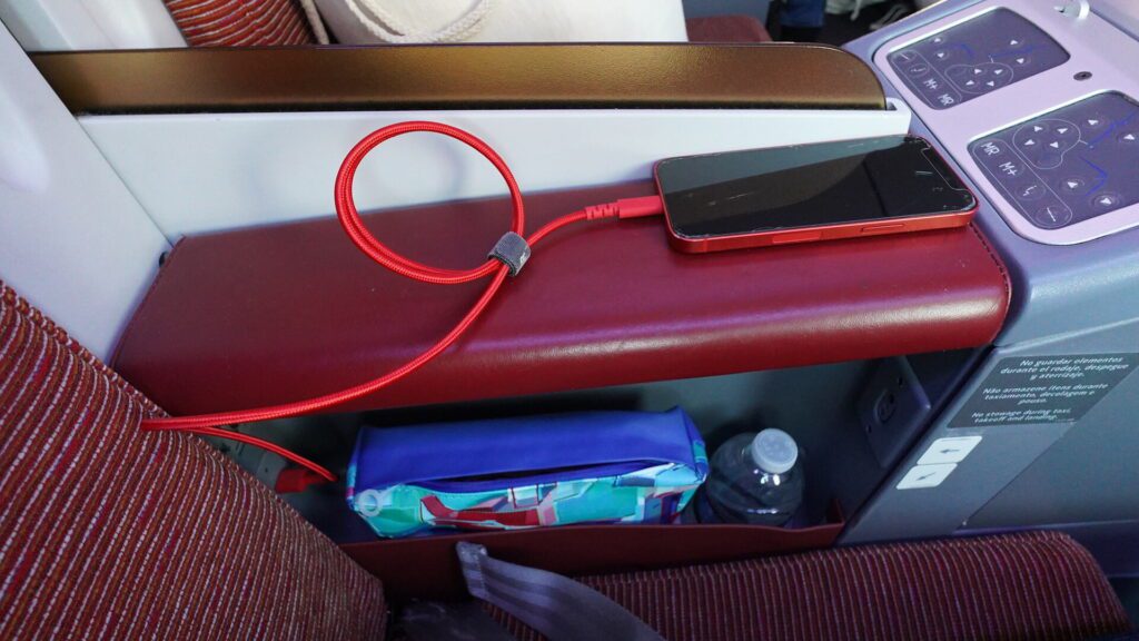 LATAM business class central cubby with water and amenity kit.