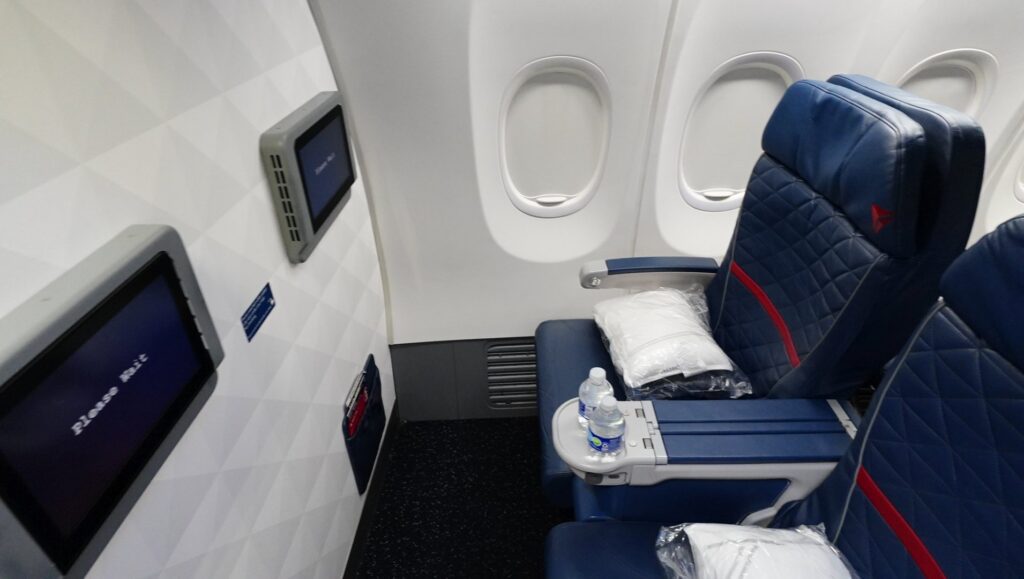 The bulkhead seats have the IFE screen on the bulkhead panel, and lack storage