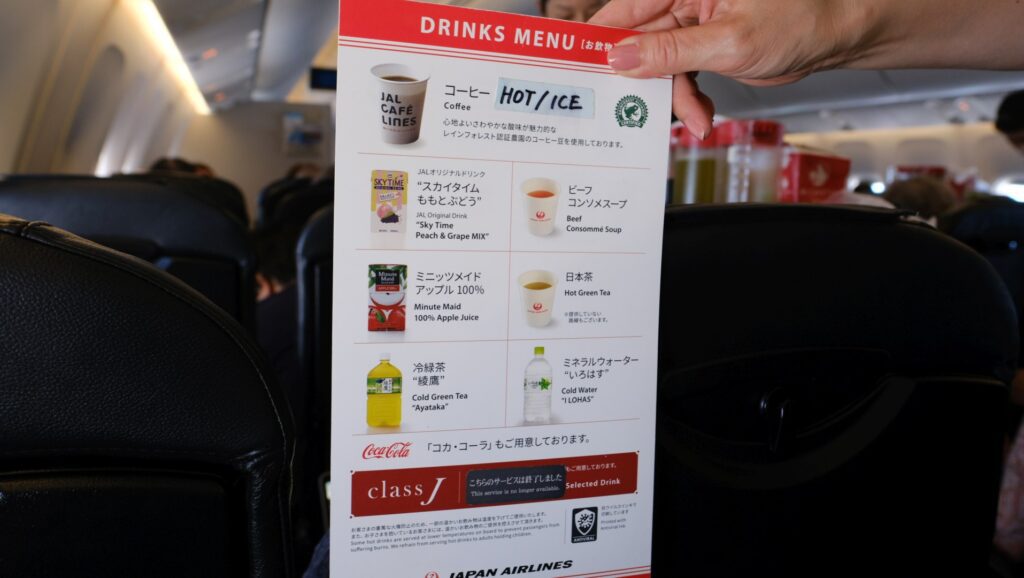 JAL meal menu, held by the flight attendant