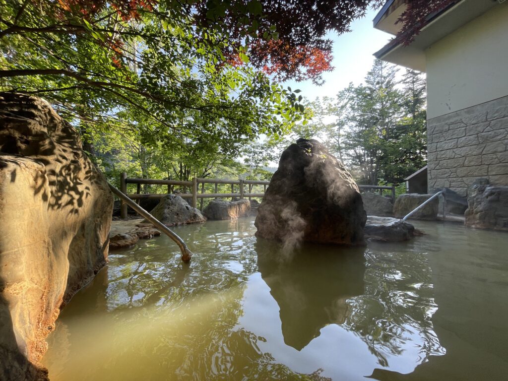 Yumoto Shirogane Onsen men's outdoor pool in the morning light, steam rising
