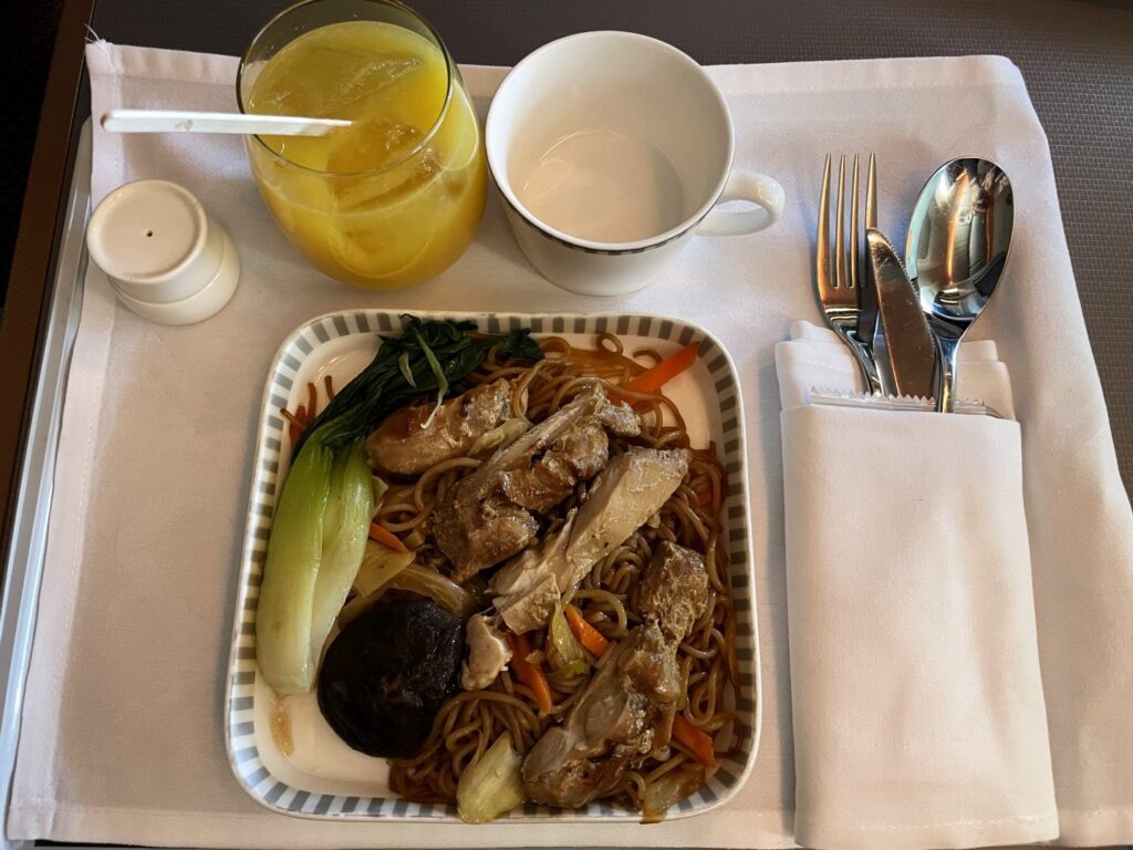 Mid flight snack of Fried Rice Vermicelli with Marinated Chicken, Chinese Mushroom, and Leafy Greens.