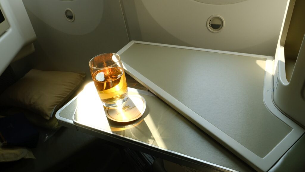 Vietnam Airlines business class Seat 4Kwith table half deployed and my pre-departure Apple juice.